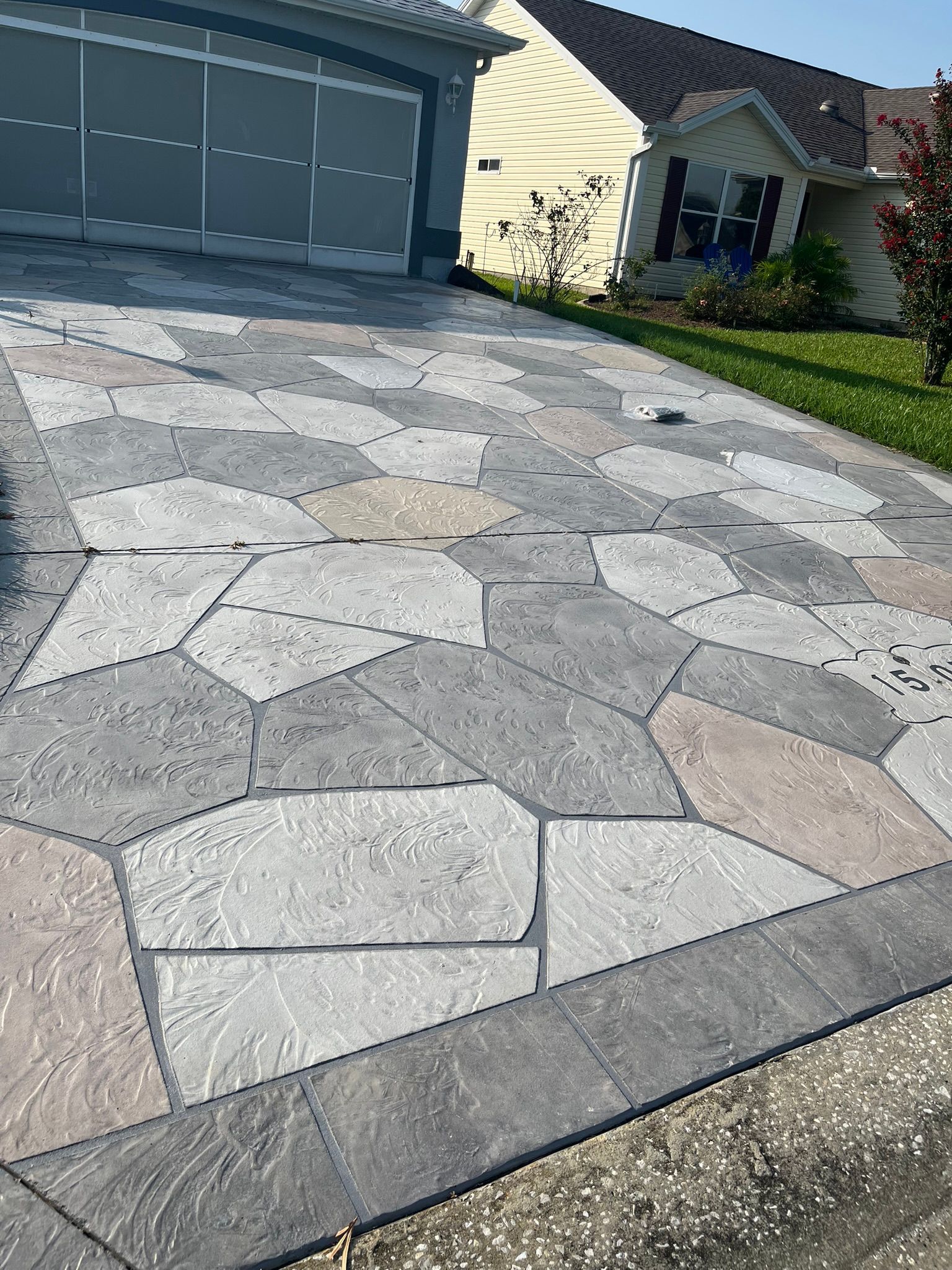 Round fire pit constructed from gray blocks, on a patio.