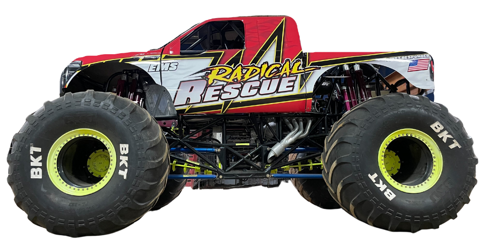 Radical Rescue monster truck, red and white with black tires, on display.