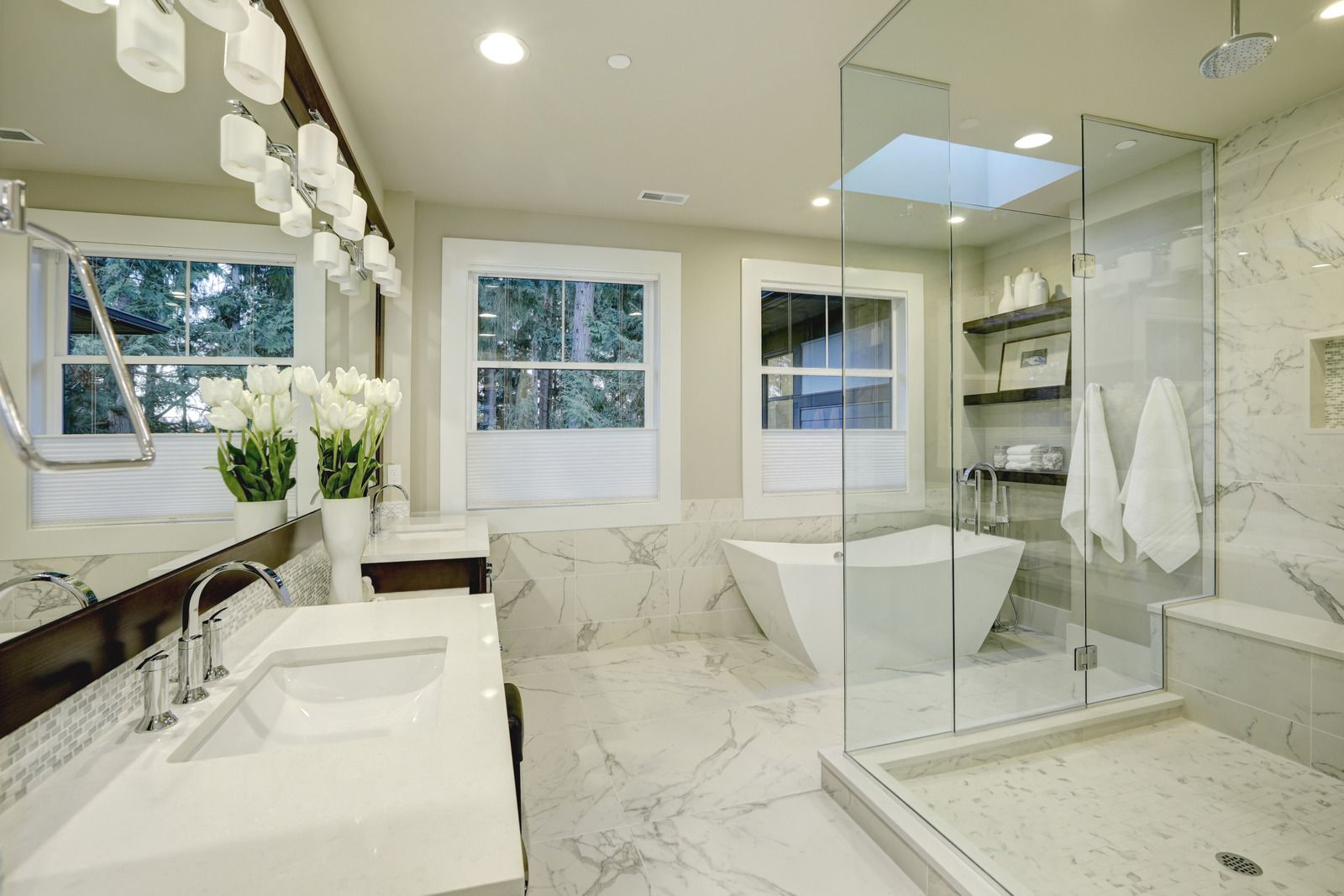 A bathroom with two sinks , a tub , and a walk in shower.