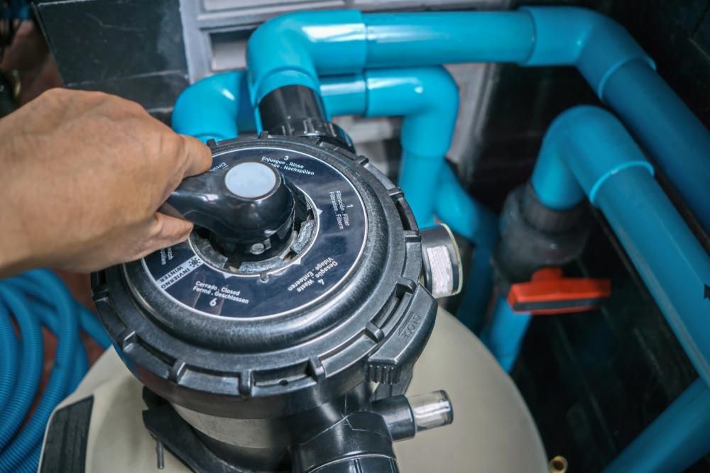 A Person is Adjusting a Valve on a Swimming Pool Filter — Whitsunday Pool Service in Cannonvale, QLD