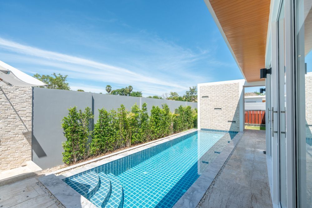 There Is a Large Swimming Pool in The Backyard of A House — Whitsunday Pool Service in Cannonvale, QLD 