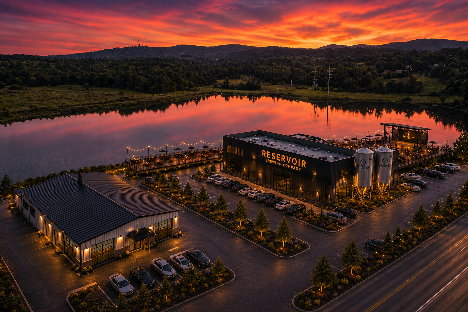 Aerial view of a lakeside resort at sunset, with warm orange sky reflecting on the water.