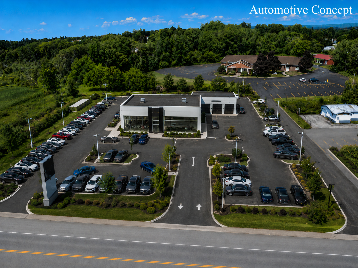 Aerial view of a modern commercial building with parking lot, surrounded by trees, lake, and mountains under a bright sun