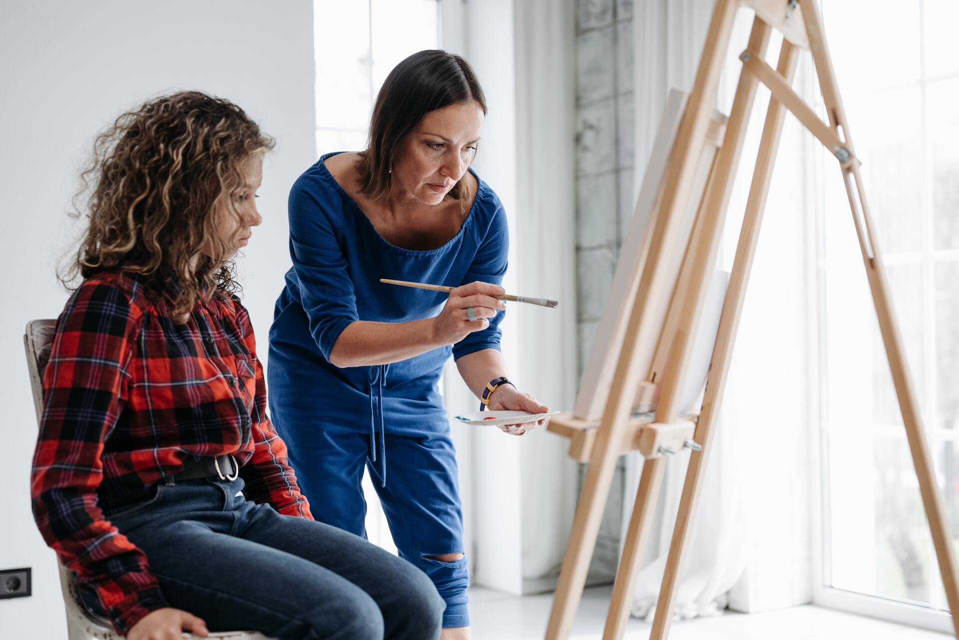 Teacher explaining to her student painting techniques