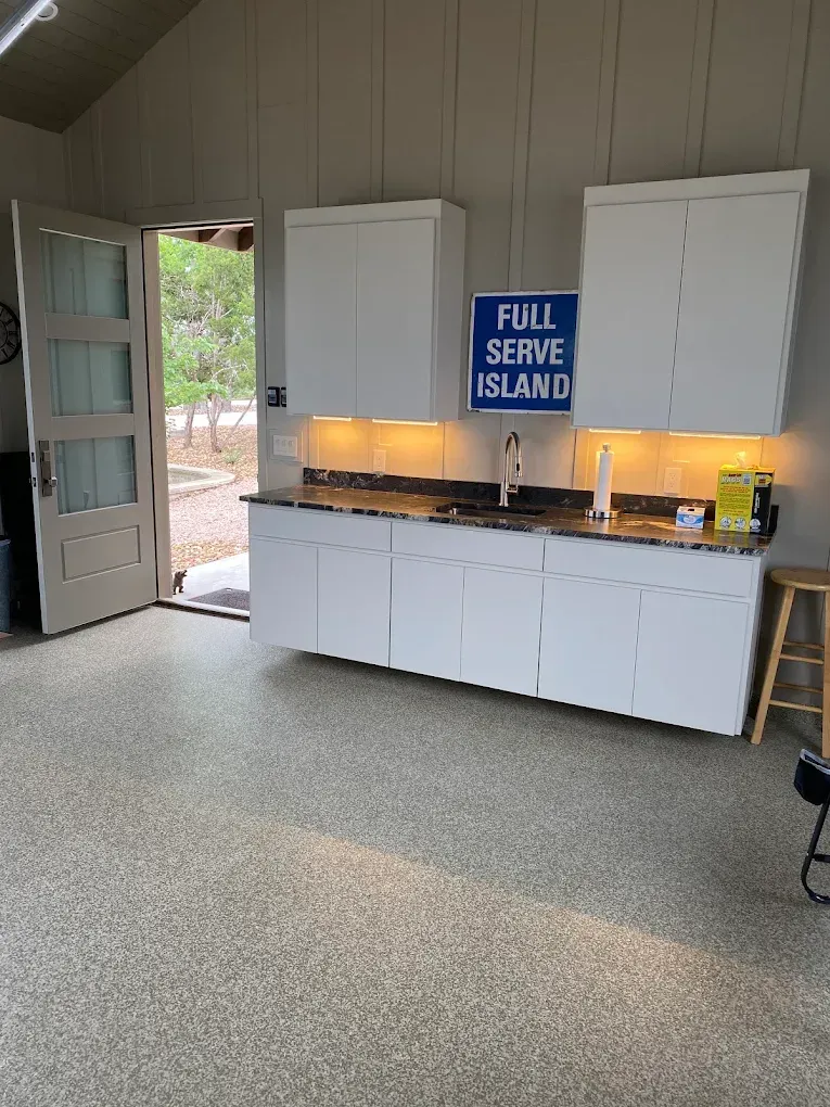 Kitchen serving area with white cabinets, a blue “FULL SERVE ISLAND” sign, and an open door to outside.