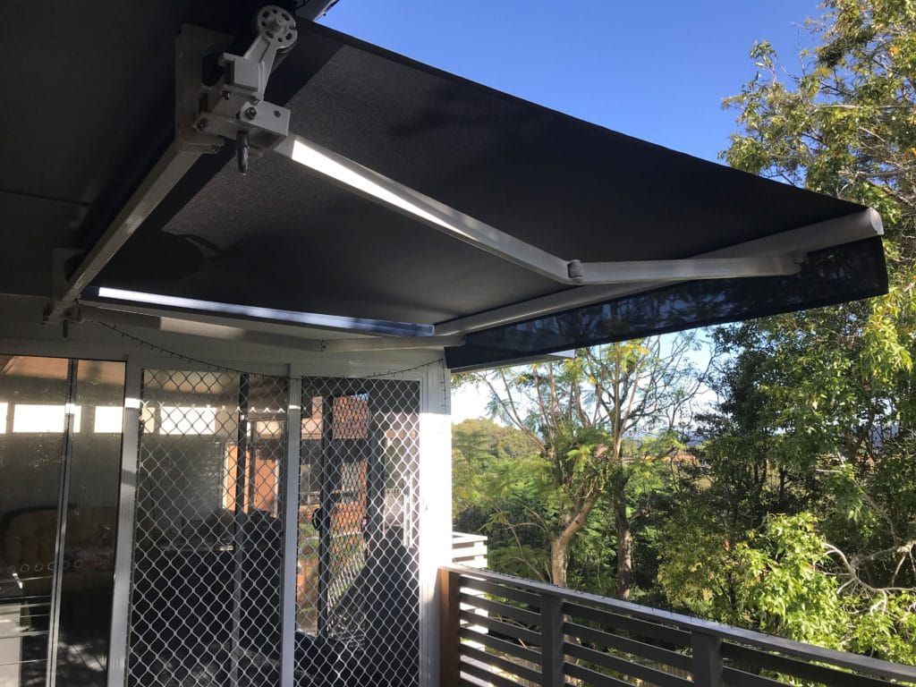 A Balcony with A Black Awning Over a Sliding Glass Door — Winning Blinds in Mayfield, NSW
