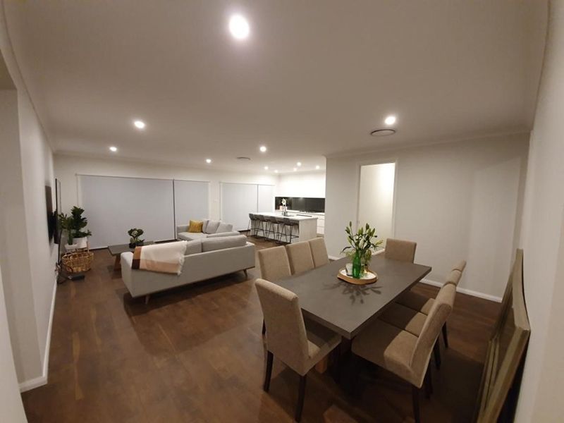 A Living Space With Dining Table And Chairs, With Shutters Closed — Winning Blinds in Cardiff, NSW