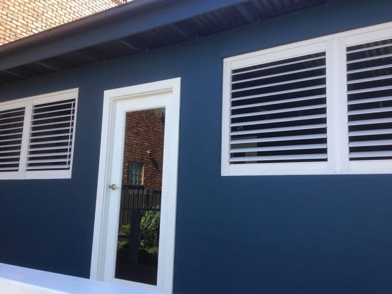 Blue Building With White Framed Door And Shuttered Windows — Winning Blinds in Cardiff, NSW