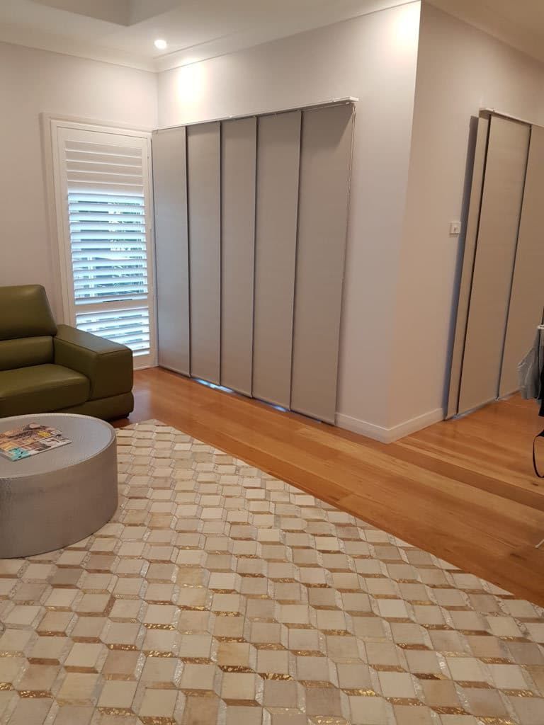 A Living Room with A Couch, Coffee Table, Rug, and Sliding Doors — Winning Blinds in Maitland, NSW