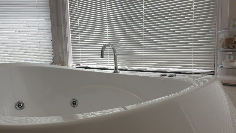 A Modern Jacuzzi Bathtub With Silver Faucet With Closed Blinds — Winning Blinds in Cardiff, NSW