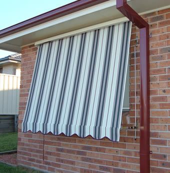 Striped Awning Shades A Brick Building's Window — Winning Blinds in Cardiff, NSW