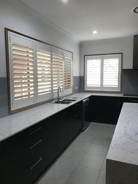 Kitchen With White Countertops, And Shuttered Windows — Winning Blinds in Cardiff, NSW
