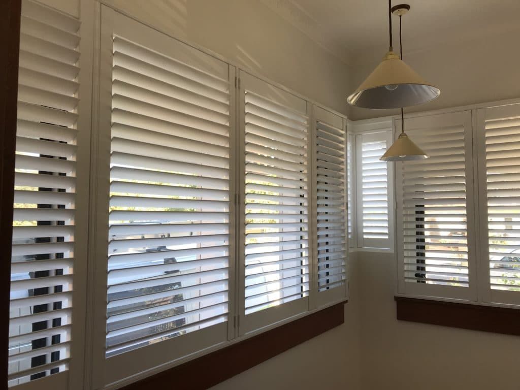 A Room with White Shutters on The Windows and A Mirror — Winning Blinds in Raymond Terrace, NSW