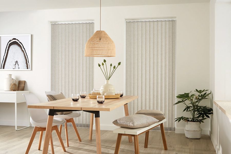 Dining Room With Light Wooden Table And Vertical Blinds — Winning Blinds in Cardiff, NSW