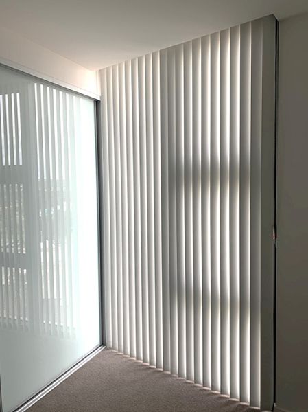 Vertical White Blinds Covering A Window And A Wall — Winning Blinds in Cardiff, NSW