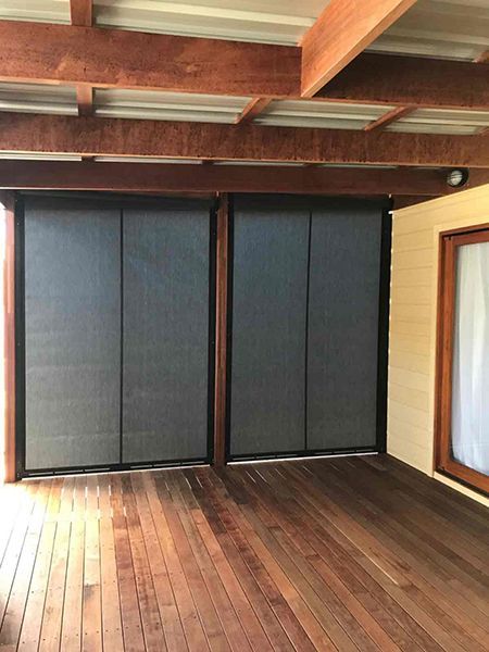 Two Dark Mesh Roller Blinds On A Wooden Deck — Winning Blinds in Cardiff, NSW