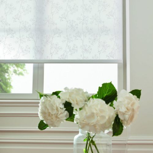 A vase of white flowers is sitting in front of a window — Winning Blinds in Cardiff, NSW