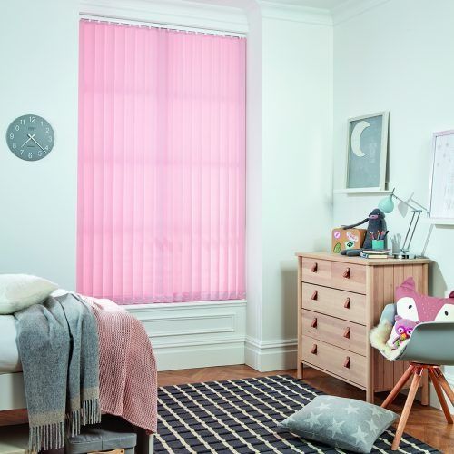 A bedroom with a bed , dresser , rug and pink vertical blinds — Winning Blinds in Cardiff, NSW