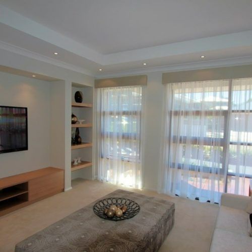 A Living Room With a Large Ottoman and Lots of Windows — Winning Blinds in Cardiff, NSW