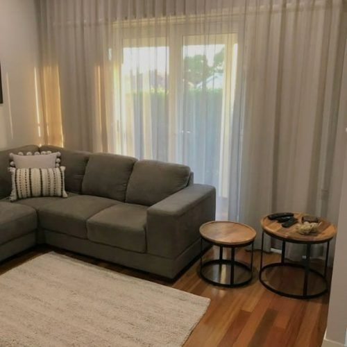A Living Room With a Couch , Two Tables and a Rug — Winning Blinds in Cardiff, NSW