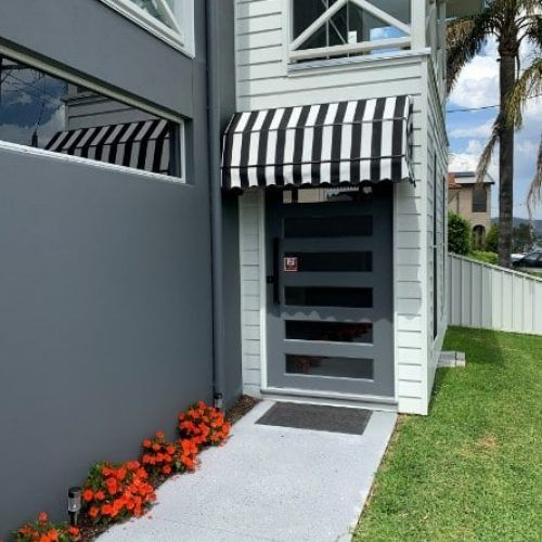 The Front Door of a House With a Black and White Awning Over It — Winning Blinds in Cardiff, NSW