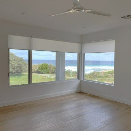 An Empty Room With a View of the Ocean and a Ceiling Fan — Winning Blinds in Cardiff, NSW