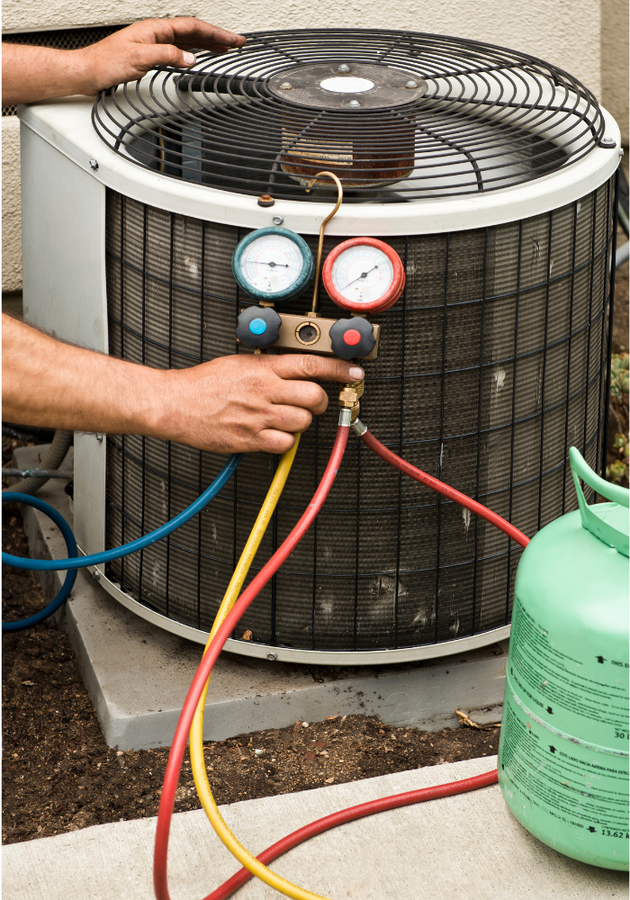 AC unit being serviced; gauges and hoses connected. Green refrigerant tank nearby.