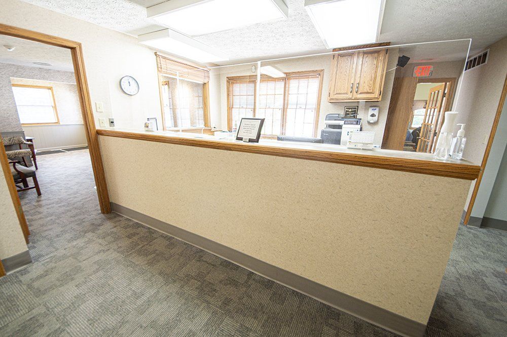 Reception area with beige countertop, windows, and office entrance.