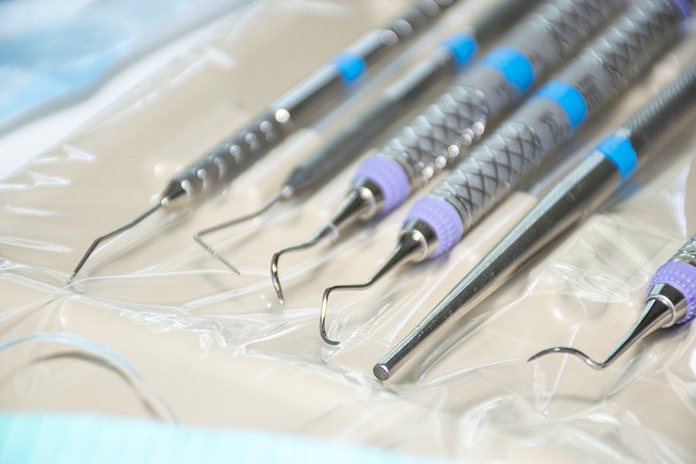 Dental instruments in a sterile package, various designs with blue and purple accents.