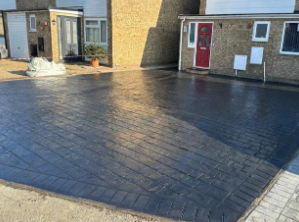 Dark patterned imprinted concrete driveway in Woking, offering a durable, stylish solution by Surrey Hills Driveways.