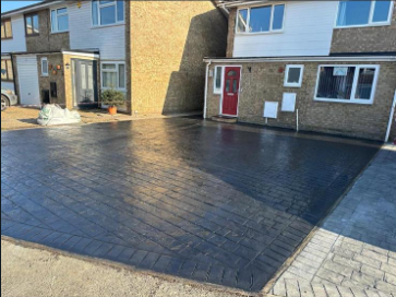 Dark patterned imprinted concrete driveway in Woking, offering a durable, stylish solution by Surrey Hills Driveways.