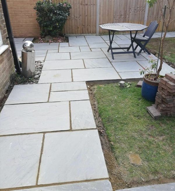 Patio installation in Woking by Surrey Hills, showing new paving and garden area.
