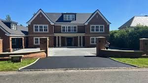 Tarmac and gravel driveway leading to a large, newly built brick house in Woking, showcasing Surrey Hills landscaping.