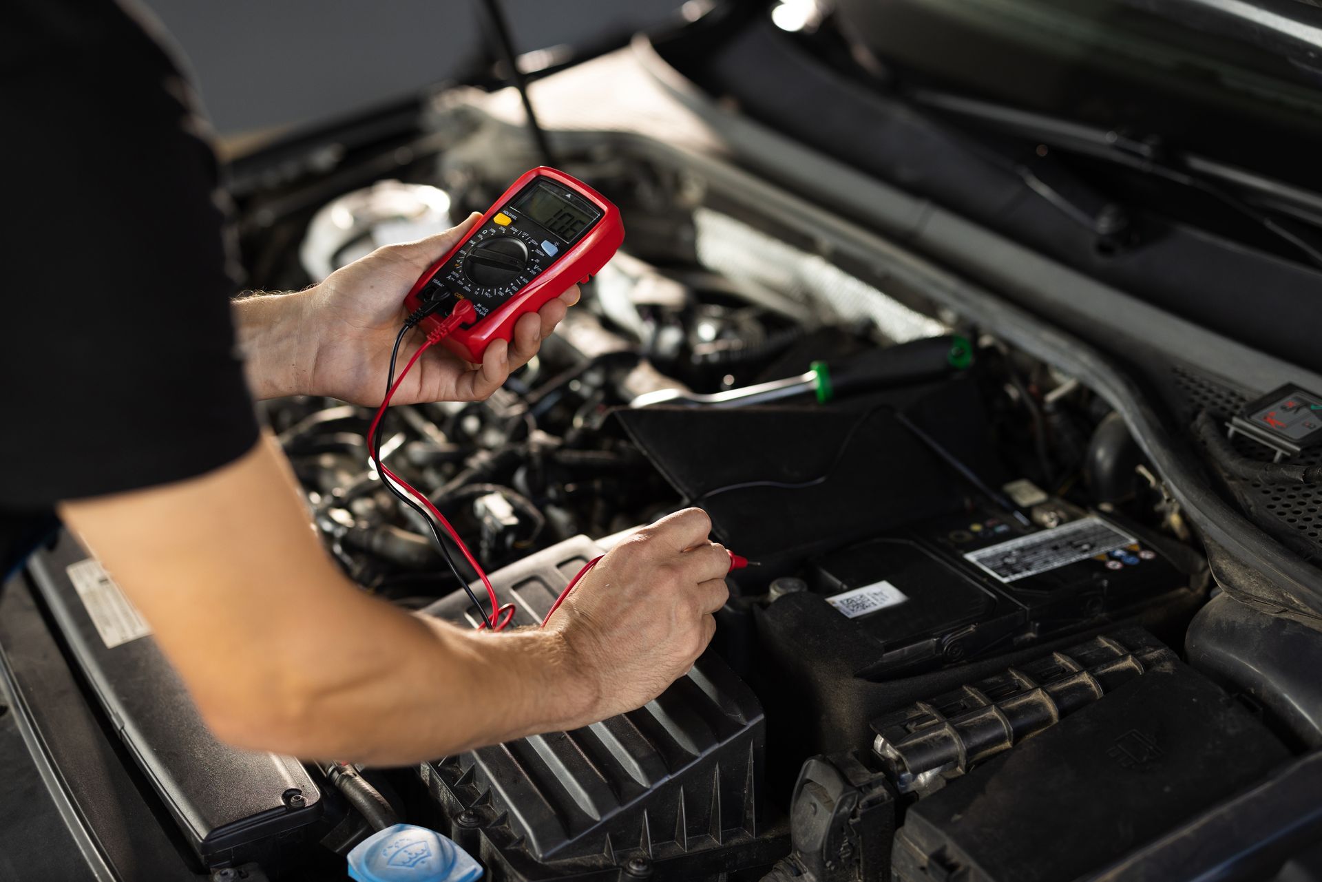 mobile mechanic working on car motor