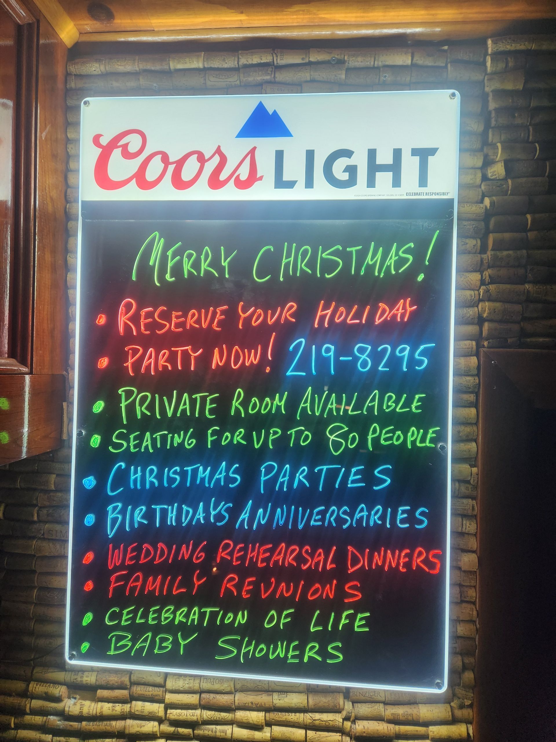 Coors Light chalkboard sign with Christmas party and holiday reservation details in red, green, and white text