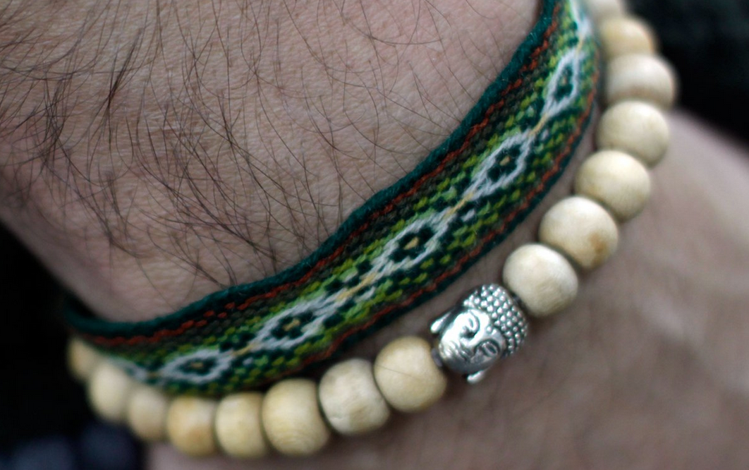 Kralenarmband met houten kralen en een zilveren Boeddha-hanger.