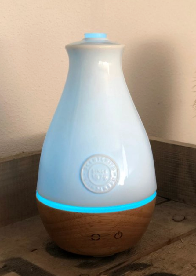 Blauwe etherische olie diffuser met houtnerfpatroon.