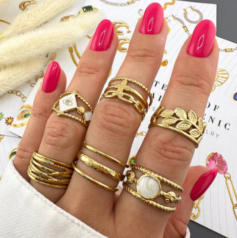 Hand met gouden ringen en een armband;