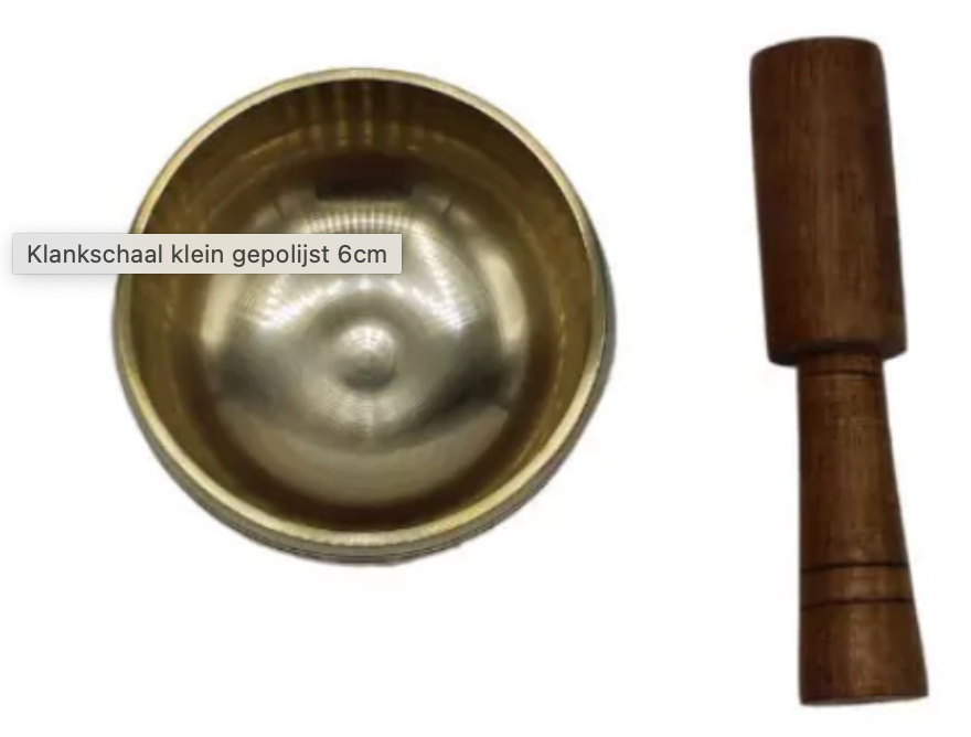 Kleine messing klankschaal met houten klopper, witte achtergrond.