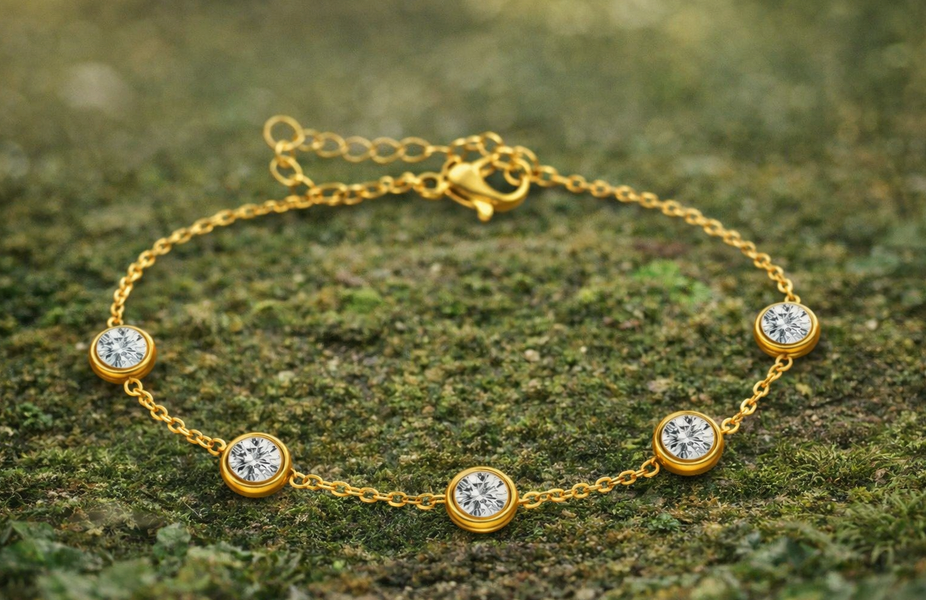 Gouden armband met vijf ronde, transparante stenen op een mosachtige ondergrond.