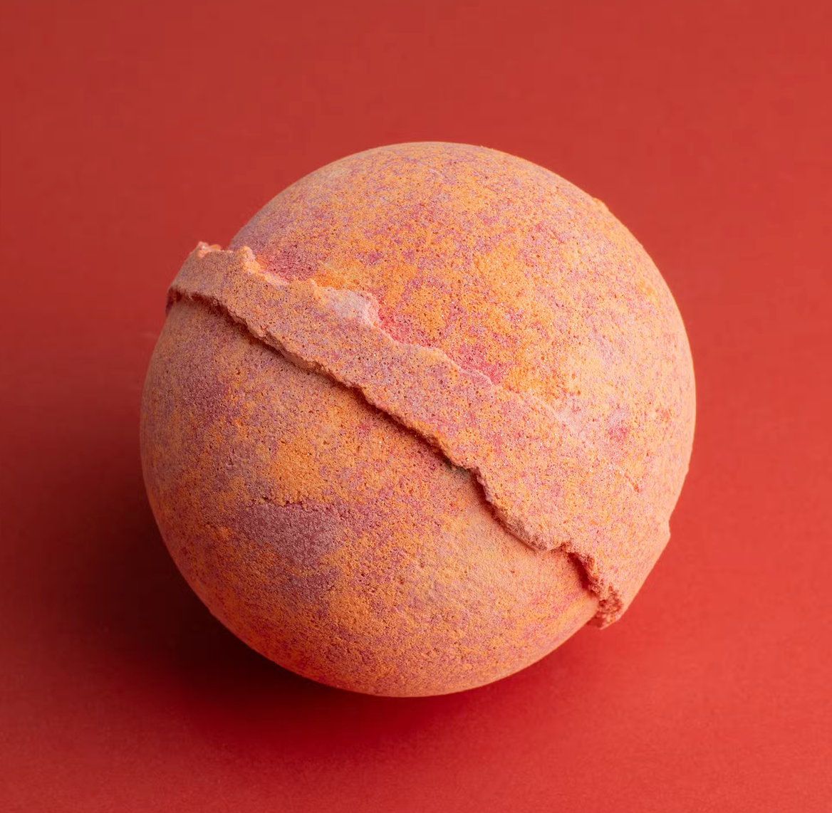 Roze bal met reliëf en een diagonale naad op een rode achtergrond