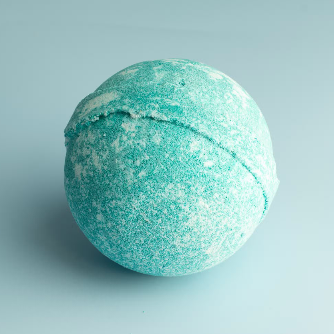 Turquoise badbruisbal met textuur op een lichtblauwe achtergrond