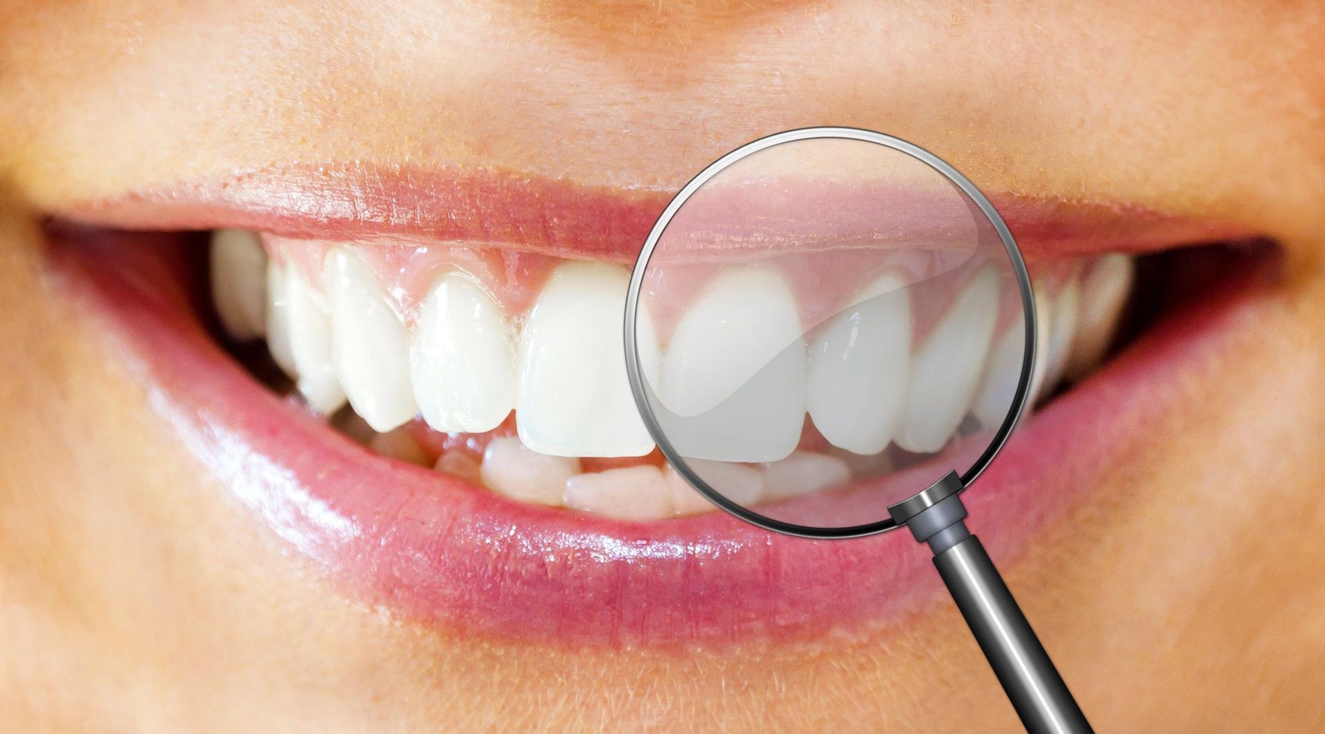 Close-up of healthy white teeth and gums with a magnifying glass inspecting them, promoting Family D