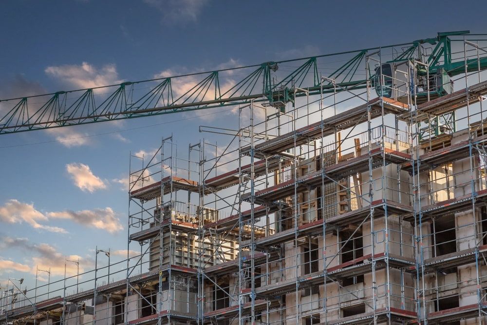 A Large Building Under Construction With Scaffolding And A Crane — Fahlstrom Scaffolding Cairns Pty Ltd in Gordonvale, QLD