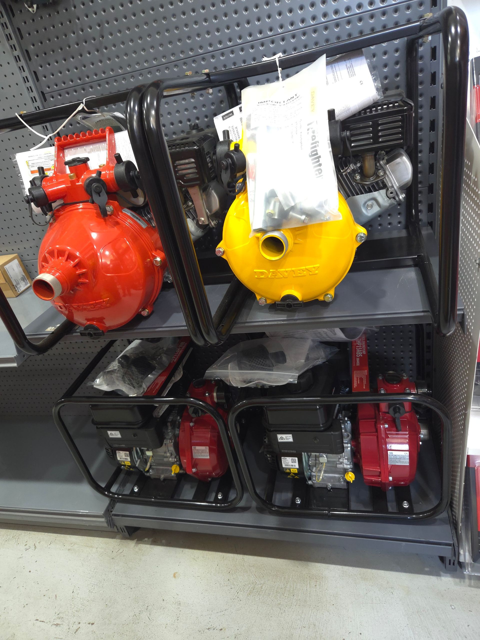 Water pumps on display in a store, including red and yellow models with black frames — Stockers & Partridge In Paterson, NSW