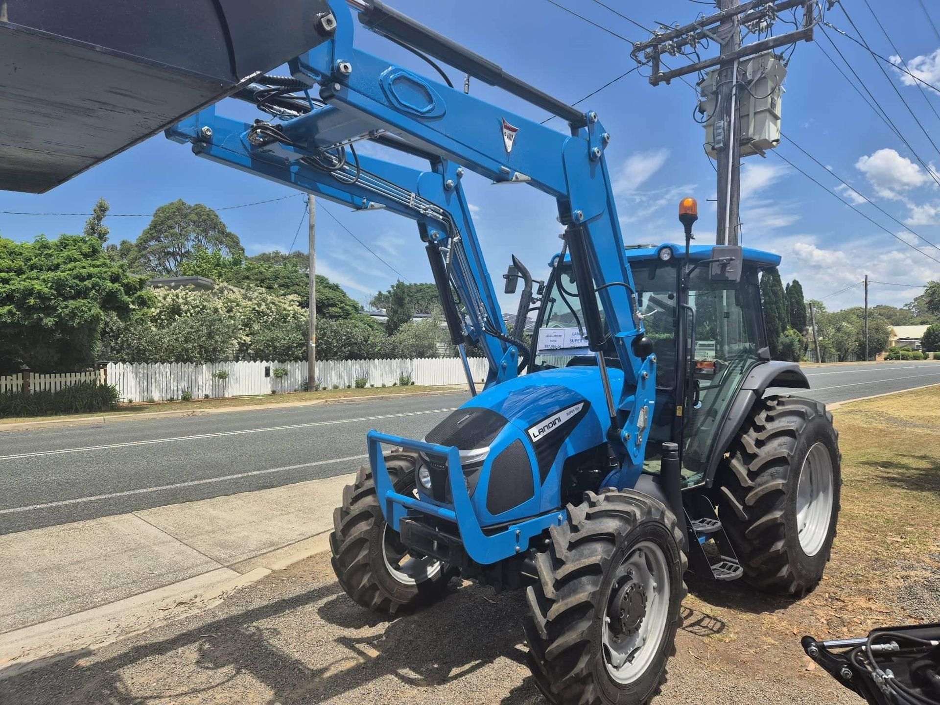 Blue Tractor With Front-end Loader Parked on a Roadside — Stockers & Partridge in Paterson, NSW