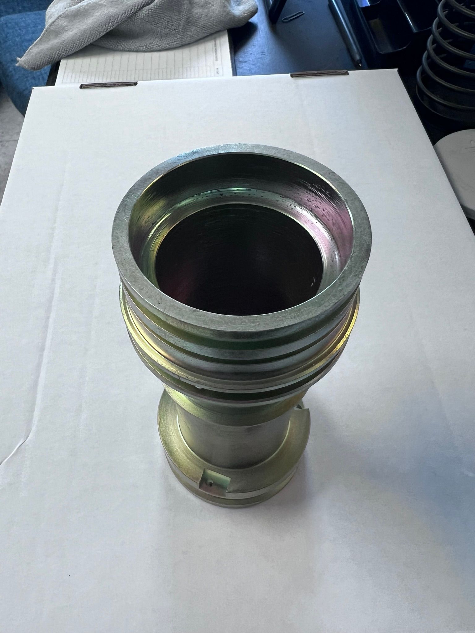 A metal object with a hole in the middle is sitting on a white table.