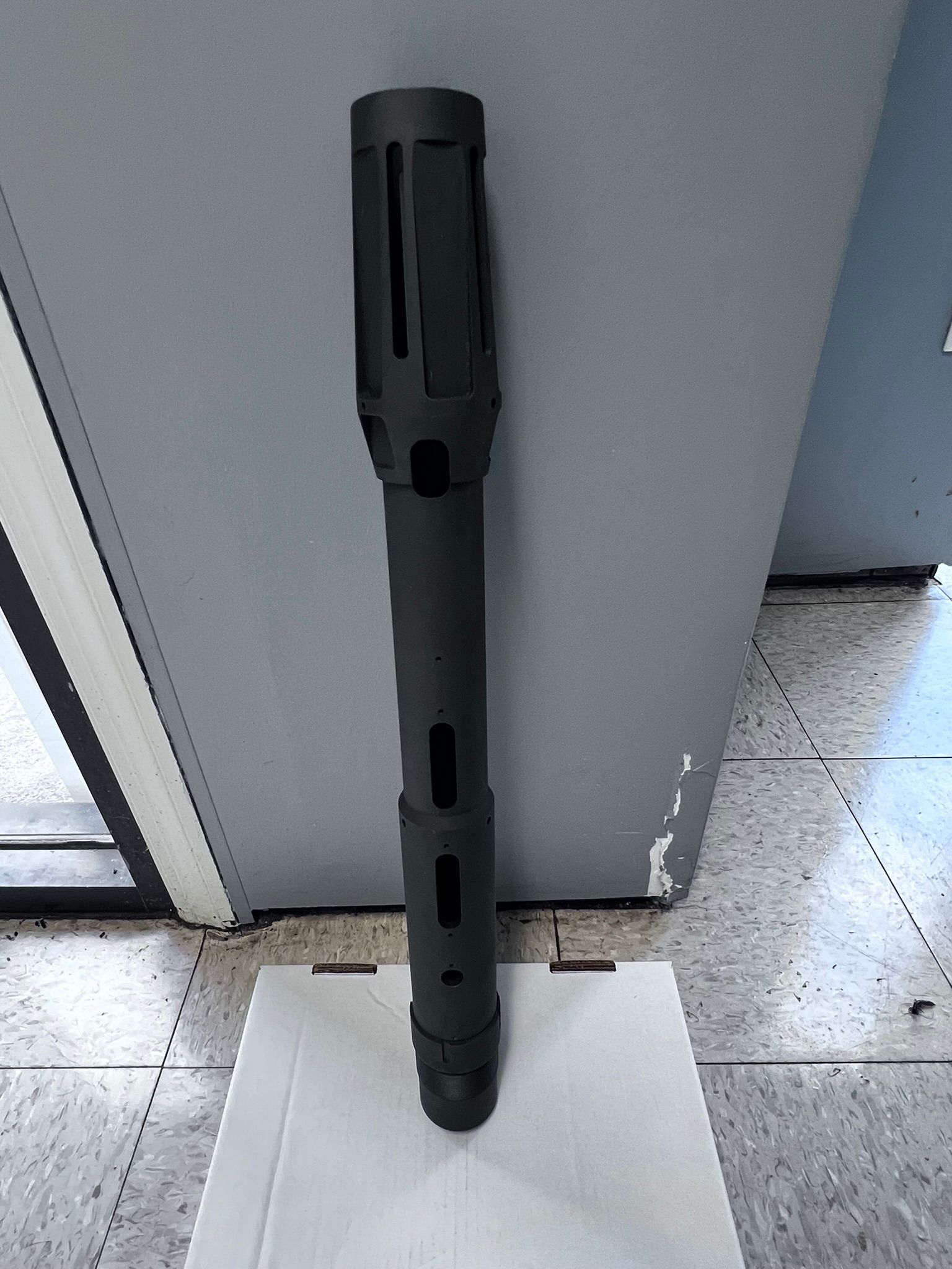 A black object is sitting on top of a white box.