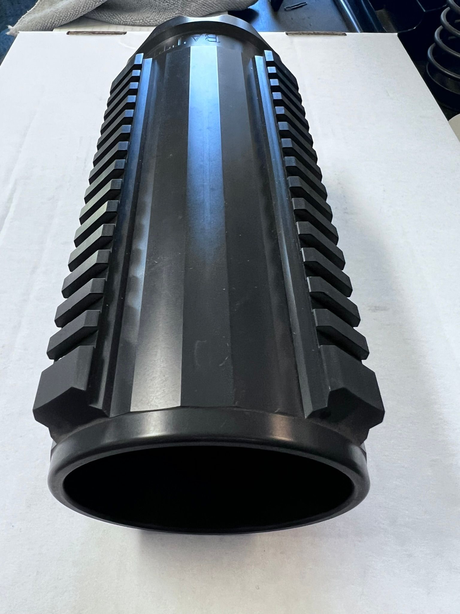 A large black object is sitting on a white surface