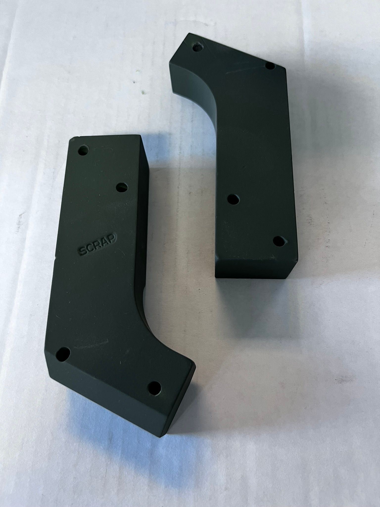 A pair of black plastic pieces with holes in them